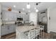 Spacious kitchen featuring gray cabinets, granite countertops, an island with seating, and stainless-steel appliances at 32718 Harmony Oaks Dr, Wesley Chapel, FL 33545