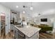 Modern kitchen with granite countertops, gray cabinetry, stainless steel appliances and seamless access to the living room at 32718 Harmony Oaks Dr, Wesley Chapel, FL 33545