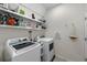Functional laundry room equipped with a washer, dryer, and shelving for storage at 32718 Harmony Oaks Dr, Wesley Chapel, FL 33545
