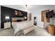 Stylish main bedroom featuring a dark accent wall, complementary decor, and natural light from windows with wood blinds at 32718 Harmony Oaks Dr, Wesley Chapel, FL 33545