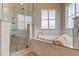Bright bathroom features a large soaking tub, a frameless glass shower and marble-look tile at 3322 Cypress Landing Dr, Valrico, FL 33596