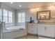 Luxurious bathroom featuring a soaking tub, dual vanities, and modern fixtures at 3322 Cypress Landing Dr, Valrico, FL 33596