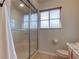 Shower with glass door, window, toilet, and tile flooring in bathroom at 3322 Cypress Landing Dr, Valrico, FL 33596