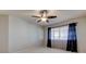 Bright bedroom featuring a ceiling fan, large window with sheer curtains, and neutral carpet at 3322 Cypress Landing Dr, Valrico, FL 33596