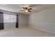Spacious bedroom featuring neutral walls, carpet flooring, and a window with light-blocking curtains at 3322 Cypress Landing Dr, Valrico, FL 33596