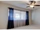 Bright bedroom featuring a ceiling fan, large window with sheer curtains, and neutral carpet at 3322 Cypress Landing Dr, Valrico, FL 33596