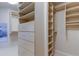 Walk-in closet features custom wood shelving, built-in drawers, and ample storage space at 3322 Cypress Landing Dr, Valrico, FL 33596