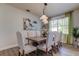 Bright dining room with a large wood table, upholstered chairs, and modern light fixture at 3322 Cypress Landing Dr, Valrico, FL 33596