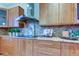 Gourmet kitchen boasts sleek cabinetry, mosaic backsplash, and stainless steel range hood at 3322 Cypress Landing Dr, Valrico, FL 33596