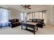 A comfortable living room setting featuring leather sofas, a ceiling fan, and patterned curtains for ambiance at 3322 Cypress Landing Dr, Valrico, FL 33596