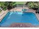 Aerial view of a backyard pool and spa surrounded by a brick patio and lush landscaping at 3322 Cypress Landing Dr, Valrico, FL 33596