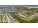 Aerial view of a lakeside community showcasing a home with a manicured lawn, lush landscaping, and serene water views at 347 Cockle Shell Loop, Apollo Beach, FL 33572