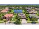 A high-angle view of a home that features well-maintained lawns, lush landscaping, and a serene pond in a Gathering-friendly neighborhood at 347 Cockle Shell Loop, Apollo Beach, FL 33572