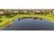 Scenic backyard view with lush green lawn meeting the tranquil water of a private pond at 347 Cockle Shell Loop, Apollo Beach, FL 33572