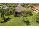 This home features a well-manicured backyard with lush green grass, mature landscaping, and a screened-in lanai for outdoor enjoyment at 347 Cockle Shell Loop, Apollo Beach, FL 33572