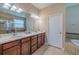 Well lit bathroom featuring a double vanity sink, quartz countertop, and tiled shower at 347 Cockle Shell Loop, Apollo Beach, FL 33572