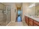 Well lit bathroom features tiled walk-in shower and double vanity with wood floors visible at 347 Cockle Shell Loop, Apollo Beach, FL 33572