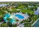 Aerial view of a community center with pools, gazebos, walking trails, and lush landscaping at 347 Cockle Shell Loop, Apollo Beach, FL 33572