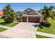 Well-maintained house featuring a spacious driveway, lush lawn, and mature palm trees at 347 Cockle Shell Loop, Apollo Beach, FL 33572