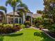 Lush front yard with mature trees, colorful flowering bushes, and impeccable landscaping at 347 Cockle Shell Loop, Apollo Beach, FL 33572