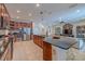 Open-concept kitchen with dark wood cabinets, tile flooring, and island overlooking the living area at 347 Cockle Shell Loop, Apollo Beach, FL 33572