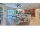 Open-concept living room and kitchen features a large sectional, glass doors, and counter seating at 347 Cockle Shell Loop, Apollo Beach, FL 33572