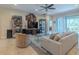 Spacious living room with tile flooring, comfortable seating, ceiling fan, and backyard views at 347 Cockle Shell Loop, Apollo Beach, FL 33572