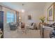Bright living room featuring stylish furniture, neutral tones, and ample natural light from the window at 347 Cockle Shell Loop, Apollo Beach, FL 33572