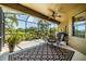 Enclosed patio features outdoor furniture, ceiling fan, and beautiful landscaping with lake view at 347 Cockle Shell Loop, Apollo Beach, FL 33572