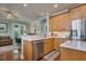 Open kitchen with light wood cabinetry, stainless steel appliances, and a view of the living area at 3714 W San Juan St, Tampa, FL 33629
