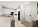 Galley kitchen with white cabinetry, black appliances, and a view of the hallway and front door at 4221 W Spruce St # 2104, Tampa, FL 33607