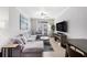 Living room with gray sectional sofa, tile floors, ceiling fan, and view of outdoor patio at 4221 W Spruce St # 2104, Tampa, FL 33607