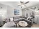 Bright living room featuring a gray sectional sofa, ceiling fan, and access to the outdoor patio at 4221 W Spruce St # 2104, Tampa, FL 33607