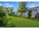 Expansive green lawn with mature trees surrounding the back of a well-maintained residential building at 4325 58Th N Way # 1527, Kenneth City, FL 33709