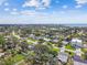 Expansive aerial view of a community with well-maintained homes surrounded by trees and glimpses of the ocean at 4400 Helena Ne St, St Petersburg, FL 33703