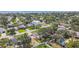 Aerial view showcases a neighborhood with mature trees, fenced yards, and a sparkling blue swimming pool at 4400 Helena Ne St, St Petersburg, FL 33703