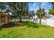 Spacious backyard with lush green grass, white privacy fence, and mature trees at 4400 Helena Ne St, St Petersburg, FL 33703