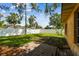 Backyard showing brick patio, mature trees, and white fence, offering privacy at 4400 Helena Ne St, St Petersburg, FL 33703