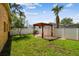 Inviting backyard featuring a pergola, well-maintained lawn, and white privacy fence at 4400 Helena Ne St, St Petersburg, FL 33703