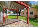 A backyard showcasing a red pergola, gravel groundcover, and lush lawn, complementing the home's exterior at 4400 Helena Ne St, St Petersburg, FL 33703