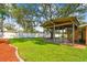 Large backyard featuring a covered patio, lush lawn, and a pristine white fence at 4400 Helena Ne St, St Petersburg, FL 33703