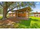 Wide backyard featuring a covered patio, mature shade tree, and well-manicured lawn at 4400 Helena Ne St, St Petersburg, FL 33703