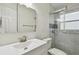 Updated bathroom featuring a modern vanity, mirror, and a glass-enclosed shower with blue tile accents at 4400 Helena Ne St, St Petersburg, FL 33703