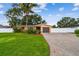 Well-maintained single-story home with a brick driveway, mature landscaping, and privacy fence at 4400 Helena Ne St, St Petersburg, FL 33703