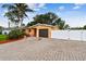Well-maintained single-story home with a brick driveway, mature landscaping, and privacy fence at 4400 Helena Ne St, St Petersburg, FL 33703