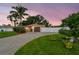 Single-story home at dusk featuring a well-maintained lawn, brick driveway, and privacy fence at 4400 Helena Ne St, St Petersburg, FL 33703