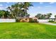 Expansive green lawn and lush landscaping surrounding a cozy single-story home with privacy fence at 4400 Helena Ne St, St Petersburg, FL 33703