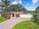 Charming home with a lush lawn, a brick driveway, and mature palm trees at 4400 Helena Ne St, St Petersburg, FL 33703