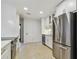 Renovated kitchen featuring white cabinets, stainless steel appliances, and terrazzo flooring at 4400 Helena Ne St, St Petersburg, FL 33703