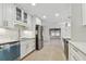 Bright kitchen with white cabinetry, stainless steel appliances, and open layout to the living area at 4400 Helena Ne St, St Petersburg, FL 33703
